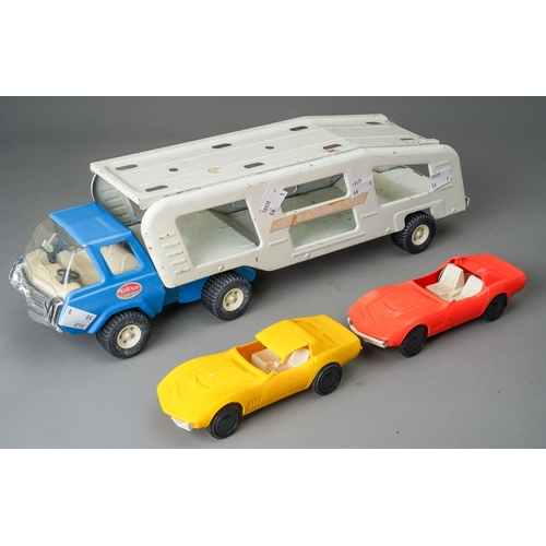 90 - Tonka Toys.  A medium scale articulated car transporter, blue cab, white body, with 2 plastic cars (... 