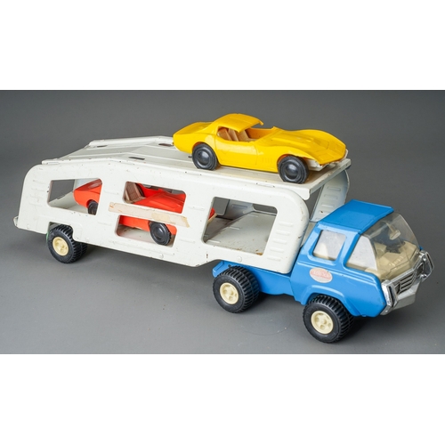 90 - Tonka Toys.  A medium scale articulated car transporter, blue cab, white body, with 2 plastic cars (... 