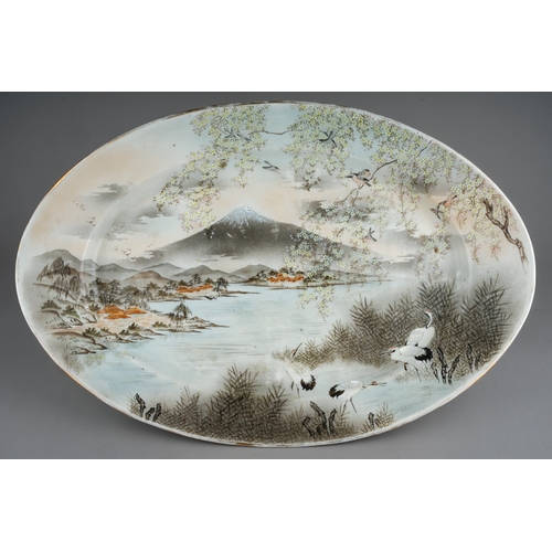 173 - An early 20th Century Japanese Export oval earthenware dish, the entire painted with river landscape... 