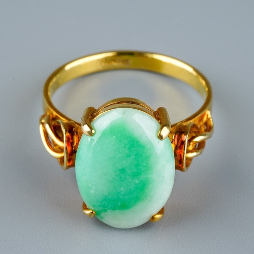 10 - A 14k yellow gold and jade ring, set with an oval cabochon stone in four claw settings, detailed sho... 