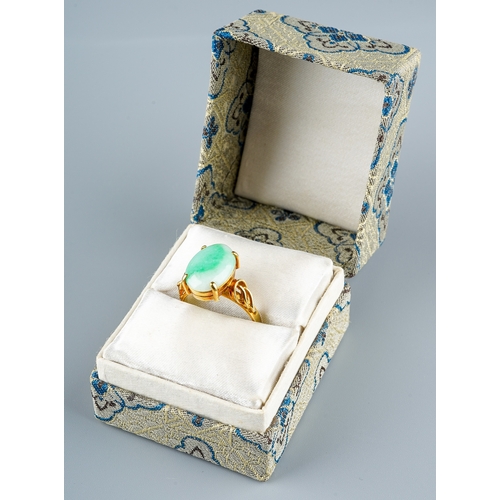 10 - A 14k yellow gold and jade ring, set with an oval cabochon stone in four claw settings, detailed sho... 