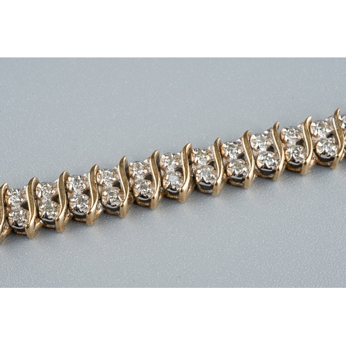 25 - A 9ct gold and diamond line bracelet, with two round brilliant-cut diamond set links between S shape... 