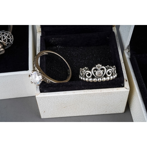 61 - A collection of silver jewellery, including two Pandora bracelets, rings, silver and CZ rings, gold-... 