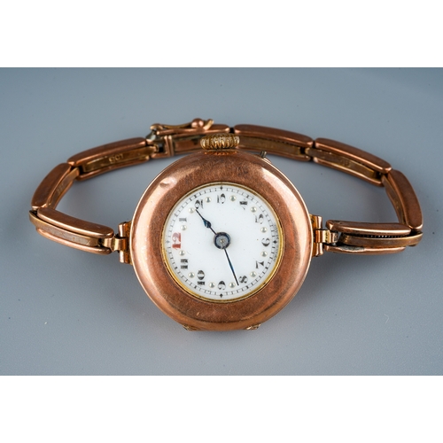 75 - A 1930s 9ct rose gold watch, white enamel dial with Arabic numerals, integral expanding 9ct stap, to... 