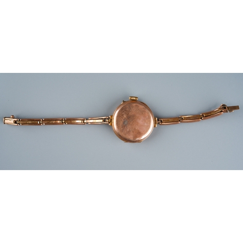 75 - A 1930s 9ct rose gold watch, white enamel dial with Arabic numerals, integral expanding 9ct stap, to... 