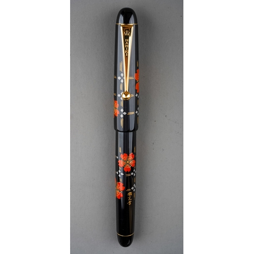 364 - A Japanese Namiki red and gold lacquer fountain pen, the barrel and cover with red flower and trelli... 