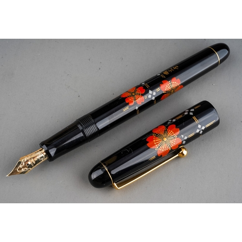 364 - A Japanese Namiki red and gold lacquer fountain pen, the barrel and cover with red flower and trelli... 