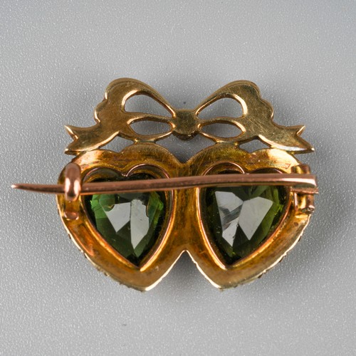 52 - A Victorian yellow metal double heart brooch, set with heart-shaped green paste stones, within a bor... 