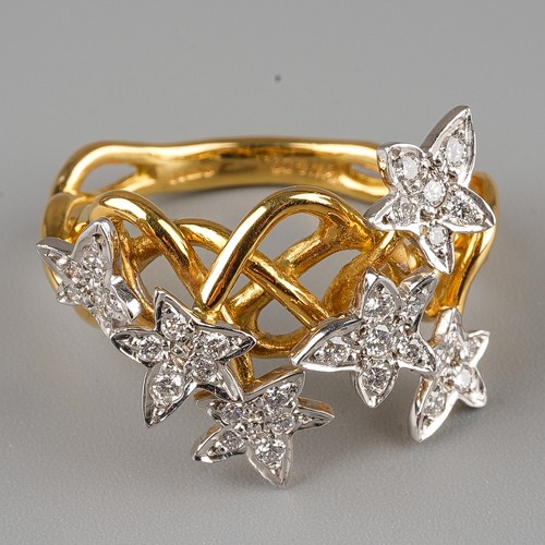 60 - An 18ct gold and diamond dress ring, the intertwined shank applied with six stars set with round bri... 