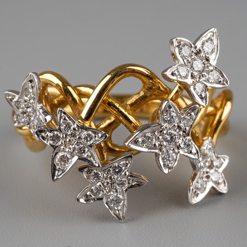 60 - An 18ct gold and diamond dress ring, the intertwined shank applied with six stars set with round bri... 