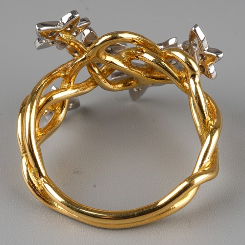 60 - An 18ct gold and diamond dress ring, the intertwined shank applied with six stars set with round bri... 