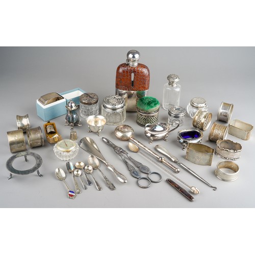 228 - A collection of silver, including eleven silver napkin rings, silver topped dressing table jars, spo... 