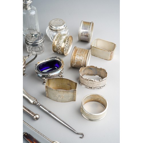 228 - A collection of silver, including eleven silver napkin rings, silver topped dressing table jars, spo... 