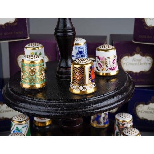 473 - A collection of  thirteen Royal Crown Derby thimbles, in numbered boxed and stand (1 bag)