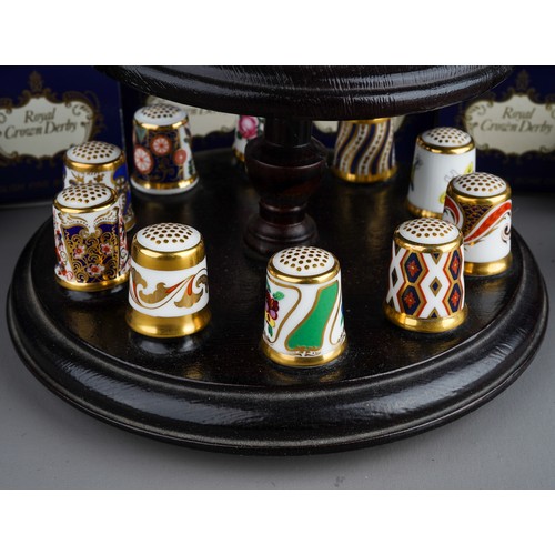 473 - A collection of  thirteen Royal Crown Derby thimbles, in numbered boxed and stand (1 bag)