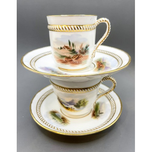 173 - Two English porcelain cups and saucers with hand painted panels and rope handles