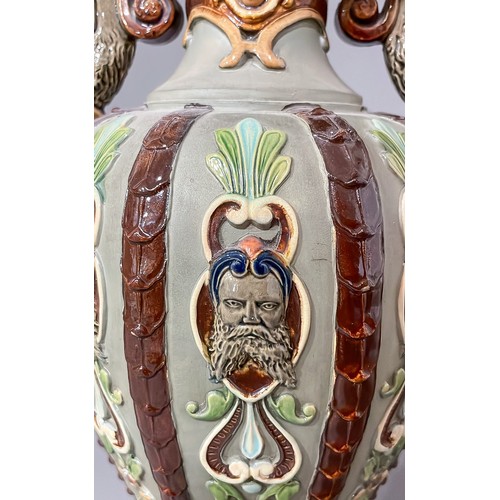 493 - A late 19th Century Majolica two handled vase, the sided with moulded strapwork with mask terminals,... 