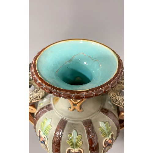 493 - A late 19th Century Majolica two handled vase, the sided with moulded strapwork with mask terminals,... 