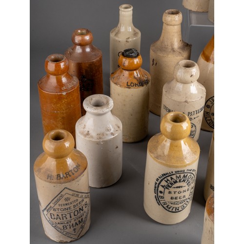 594 - Twenty-eight various stoneware beer and water bottles, some all cream, most with black transfer labe... 