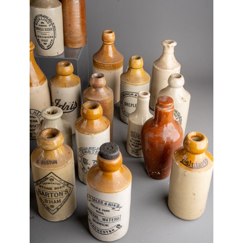 594 - Twenty-eight various stoneware beer and water bottles, some all cream, most with black transfer labe... 