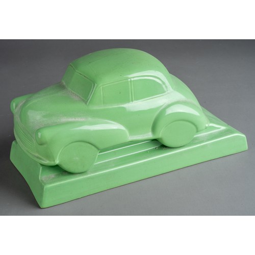 581 - A Dartmouth style desk model of ceramic green Morris Minor 1000 on separate stand with recess for pe... 