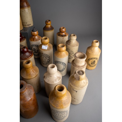 586 - Thirsty-Six stoneware ginger beer bottles, mostly Birmingham, Manchester, all with black transfer la... 