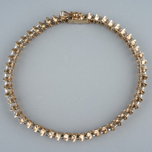 25 - A 9ct gold and diamond line bracelet, with two round brilliant-cut diamond set links between S shape... 