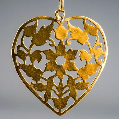 10 - A yellow gold pendant and chain, the chased and pierced heart shape pendant suspended from a square-... 