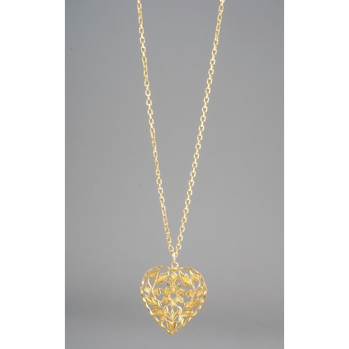 10 - A yellow gold pendant and chain, the chased and pierced heart shape pendant suspended from a square-... 