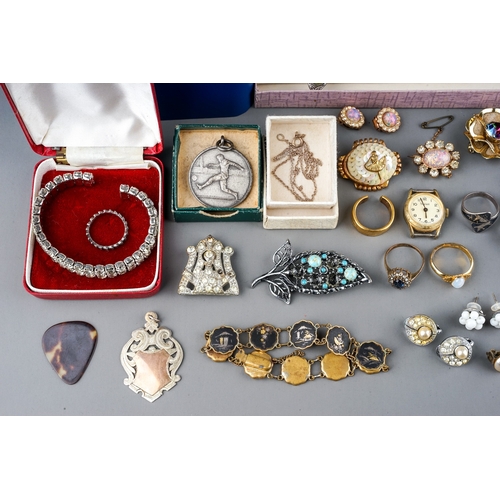 12 - A collection of costume, including brooches, earrings, faux pearls, Art Deco, football medals, marca... 