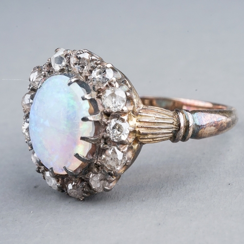 54 - An Edwardian opal and diamond dress ring, set with an oval cabochon precious opal approx 7mm x 8.6mm... 