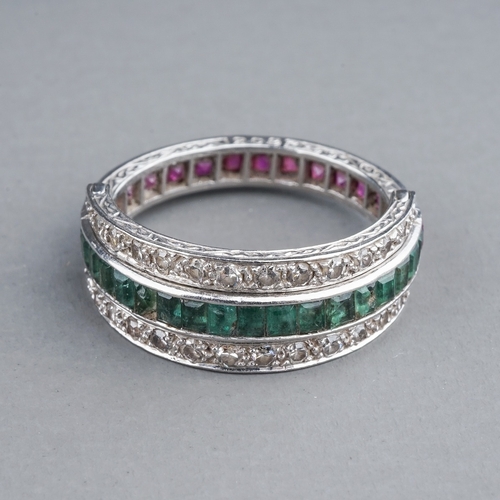 55 - An Art Deco platinum diamond ruby and emerald swivel or flip ring, set with calibre cut rubies and e... 