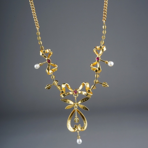 73 - An Edwardian yellow gold ruby and seed pearl necklace, three pearl-set bow motifs each centered with... 