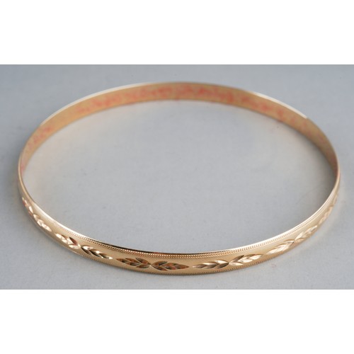 80 - A 9ct yellow gold bangle, chased with foliate design, internal diam approx 6.5cm, gross weight appro... 