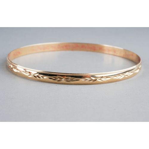 80 - A 9ct yellow gold bangle, chased with foliate design, internal diam approx 6.5cm, gross weight appro... 