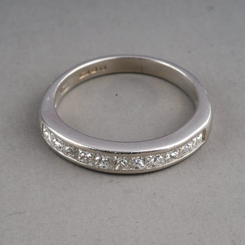 82 - A platinum and diamond half eternity ring, set with eleven princess-cut diamonds, size I1/2, gross w... 