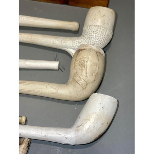 118 - A collection of clay pipes with a money box and stand (1 box)