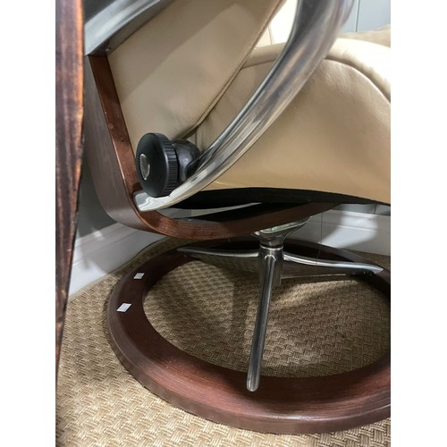 147 - A retro mid 20th century stressless reclining swivel armchair and foot stool. Having a rectangular c... 