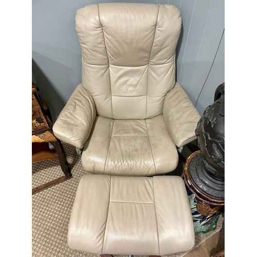 147 - A retro mid 20th century stressless reclining swivel armchair and foot stool. Having a rectangular c... 