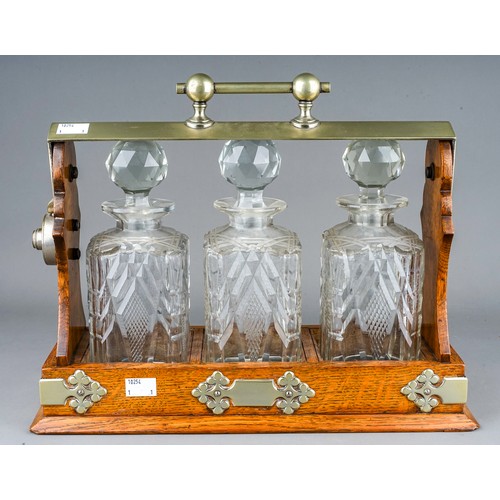 186 - An early 20th Century EPNS mounted oak tantalus fitted with three cut glass spirit decanter with sto... 