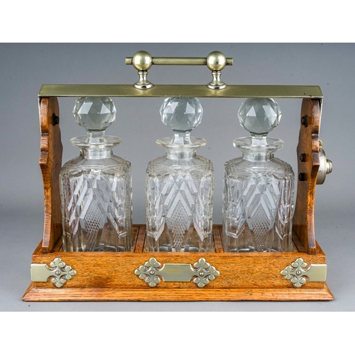 186 - An early 20th Century EPNS mounted oak tantalus fitted with three cut glass spirit decanter with sto... 