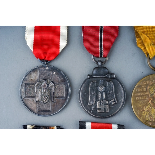 242 - A collection of 8 German Medals.  Eastern Front Medal, Mothers Cross in Bronze, War Merit Medal, Soc... 