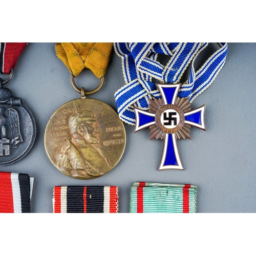 242 - A collection of 8 German Medals.  Eastern Front Medal, Mothers Cross in Bronze, War Merit Medal, Soc... 