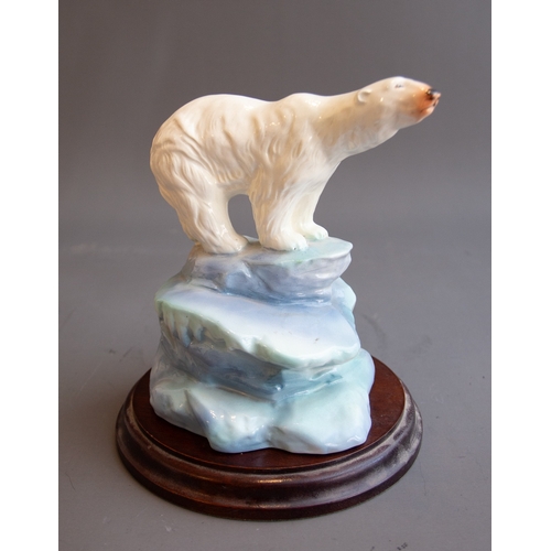 346 - A 20th Century ceramic model of a polar bear on icy plinth, unmarked, with wooden circular stand