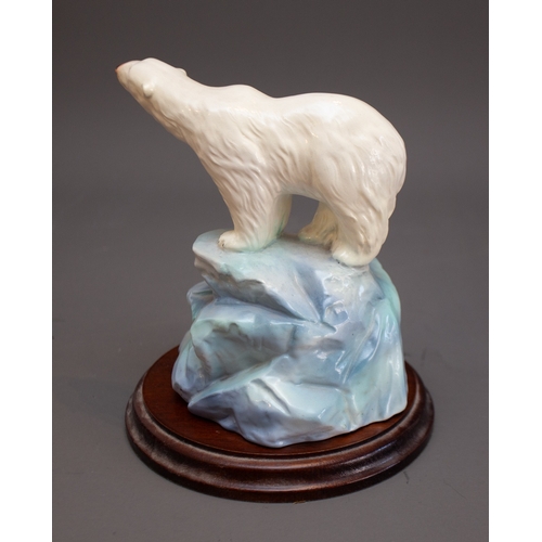 346 - A 20th Century ceramic model of a polar bear on icy plinth, unmarked, with wooden circular stand