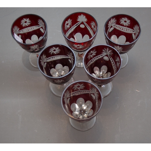 354 - A set of six Bohemian ruby glass teacups and saucers together with a set of six ruby flash glass por... 