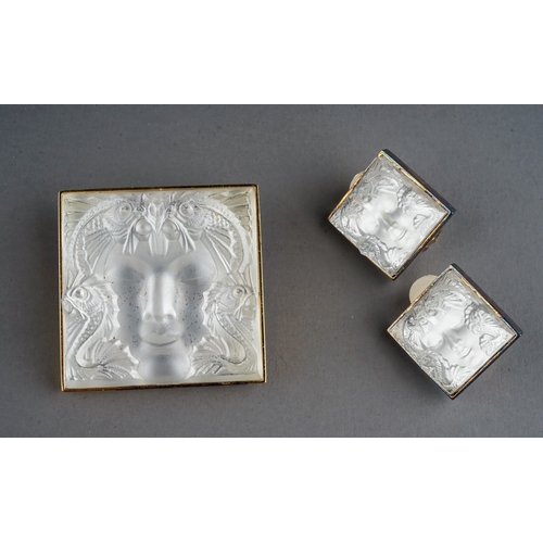 20 - Lalique - a Masque de Femme brooch, approx 3cm x 3cm; and a pair of ear clips, boxed with paperwork ... 