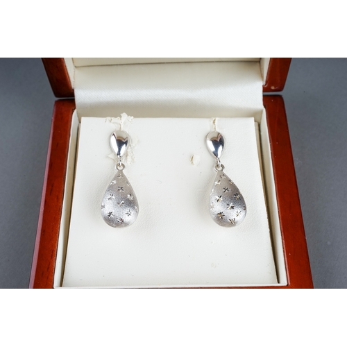 36 - A pair of Italian14k white gold drop earrings, textured pear shape drops with star detail, approx 3c... 