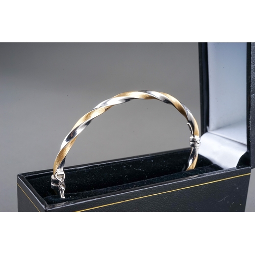 40 - An Italian 18k bi-coloured gold hinged bangle, of twisted white and yellow gold, internal width appr... 