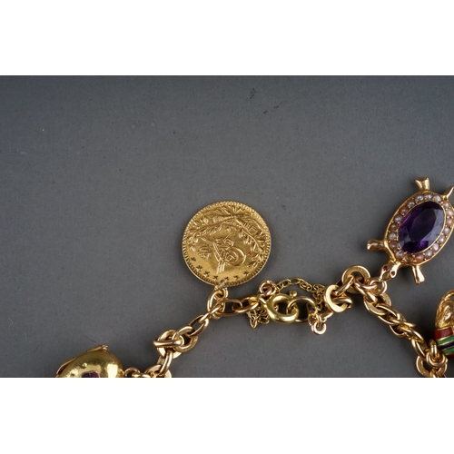 71 - A charm bracelet, suspending gold mesh purse stamped '18ct', Egyptian gold charms of camel and phara... 